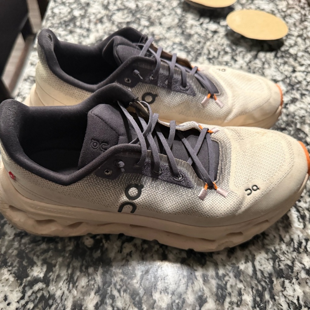 On Running Cream and Black Athletic Shoes